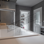 Kitchen reforms in microcement kitchens made by Cementec in which an island with an open tap can be seen.