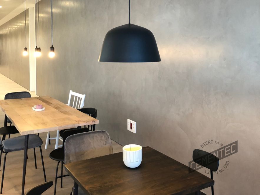 Decorative cement cladding on charcoal grey walls in Valencia restaurant