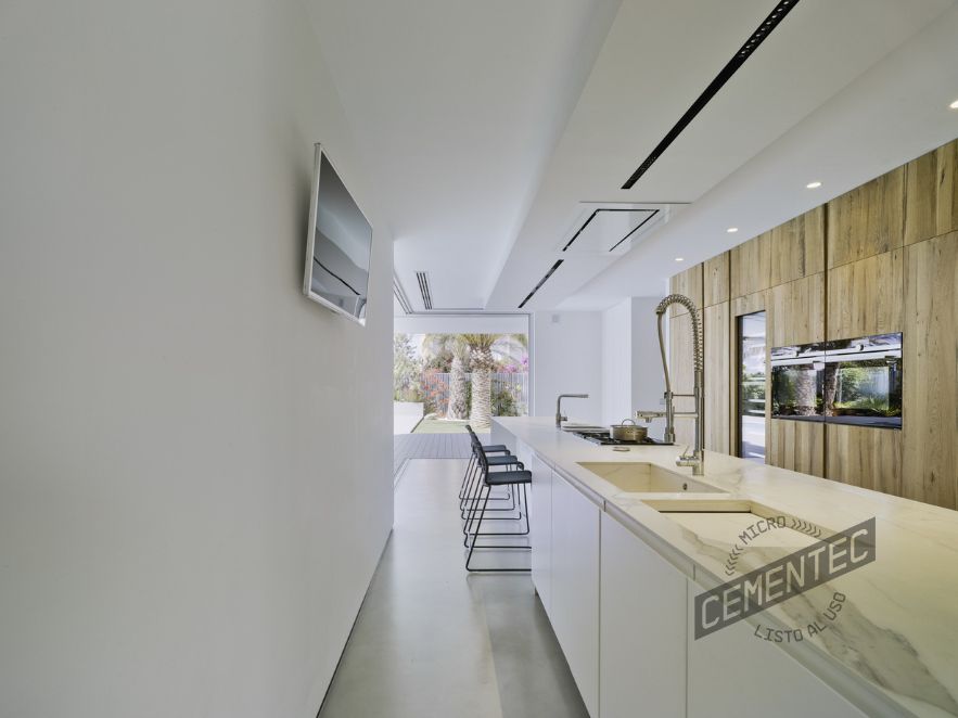 Kitchen in a house located in Valencia, where oak with "knots" in the wall is used, together with Cementec Higt Transit flooring for a more severe use.