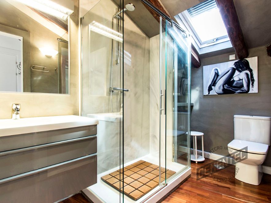 Baño en apartamento madrileño, con una perfecta elección de microcemento y madera. CEMENTEC Texture en paredes y ducha, junto con suelo en parquet.