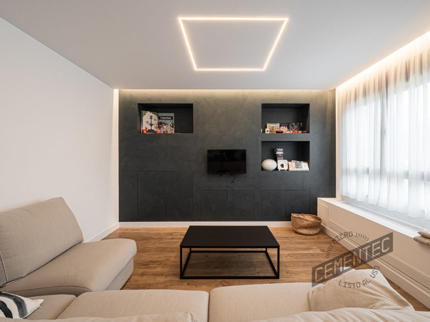 Reforma con microcemento y madera en salón comedor de vivienda unifamiliar, donde se aplica CEMENTEC Estándar Azul Báltico sobre el mueble central de pladur.