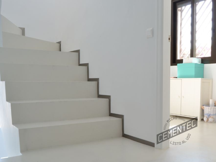 Escaleras de microcemento listo al uso de Cementec en una estancia de fondo blanco.