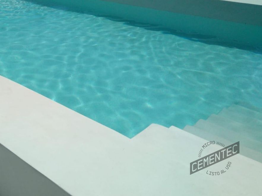 Close-up of white microcement swimming pool, with stairs covered with Cementec Pool microcement.