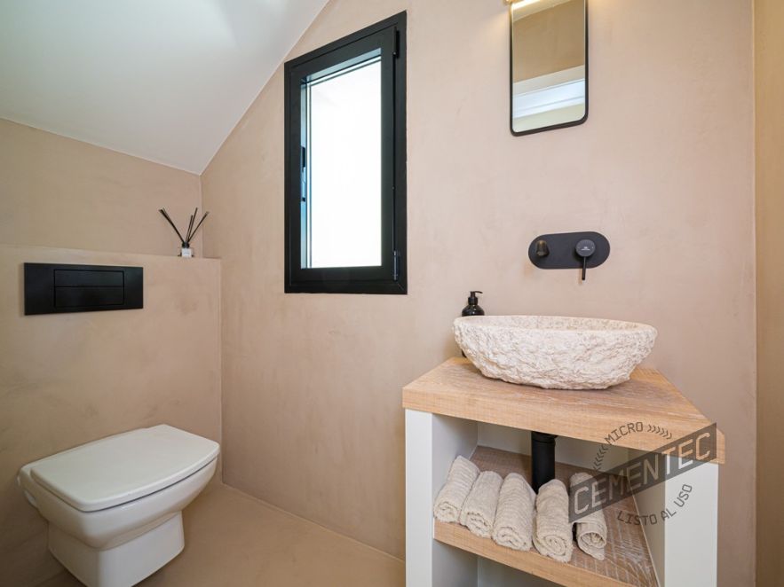 Beige microcement bathroom in attic by Cementec.
