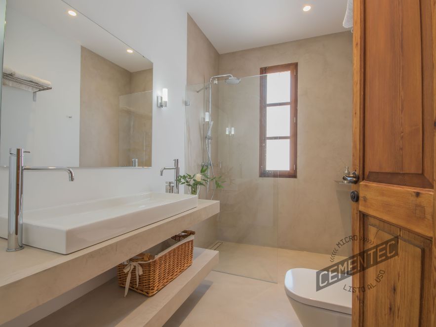 Beige microcement bathrooms in rustic style applied by Cementec.