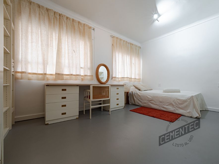 Color gris de microcemento en suelo de dormitorio infantil.