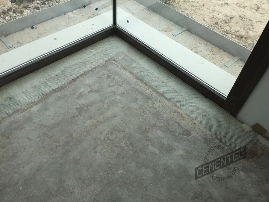 Microcement cracks or fissures in areas adjacent to sliding door enclosures.
