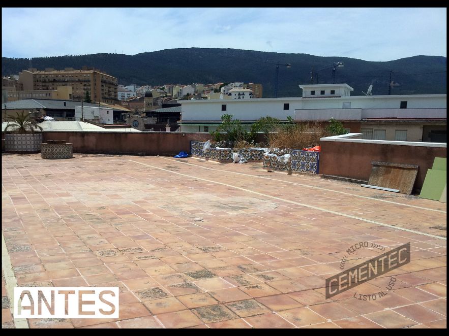 Terraza de azulejos cuadrados en el suelo con muestras de desperfectos y fisuras.