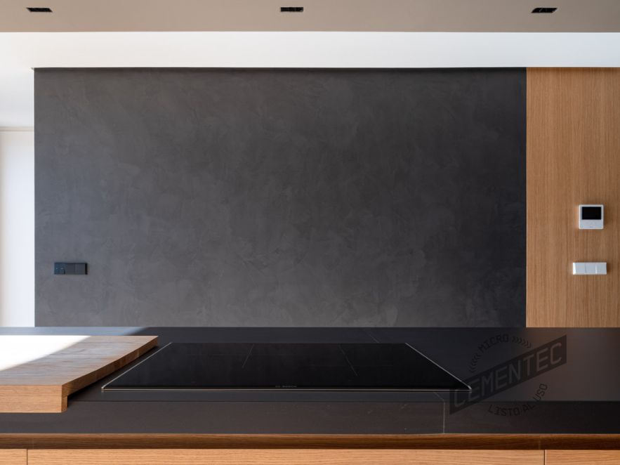 Kitchen clad in black tones combined with wood.