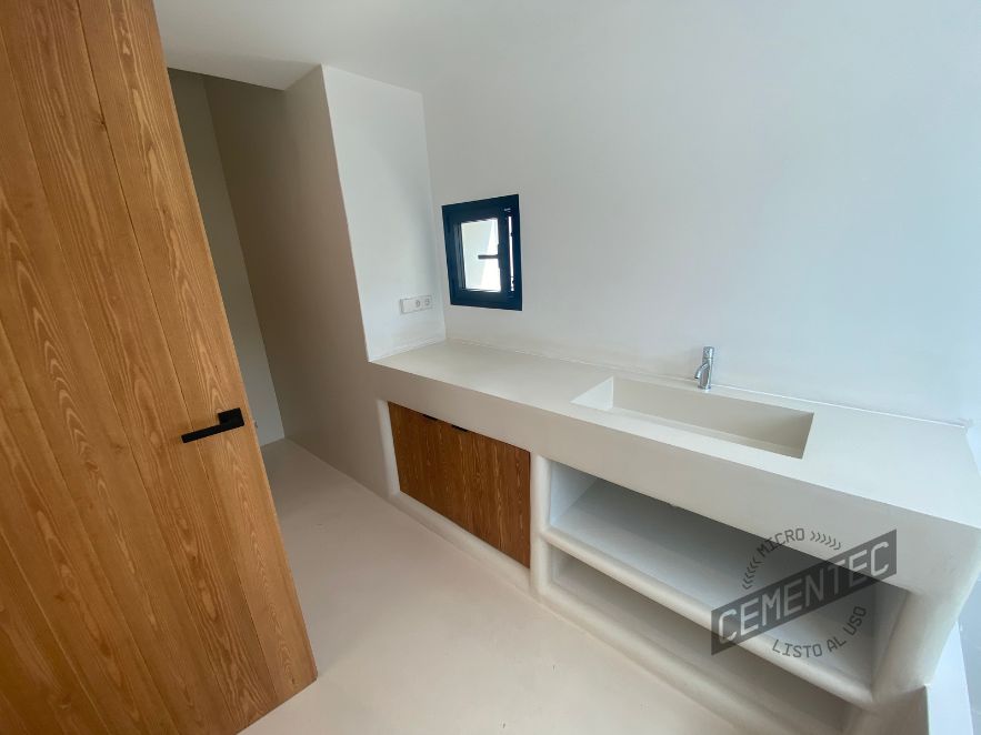 Lateral perspective of a bathroom in white microcement by Cementec.